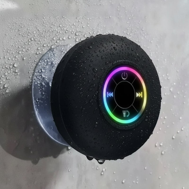 Nova Haus black waterproof Bluetooth speaker with suction cup mount, featuring colorful LED ring and control buttons, shown on a wet surface.
