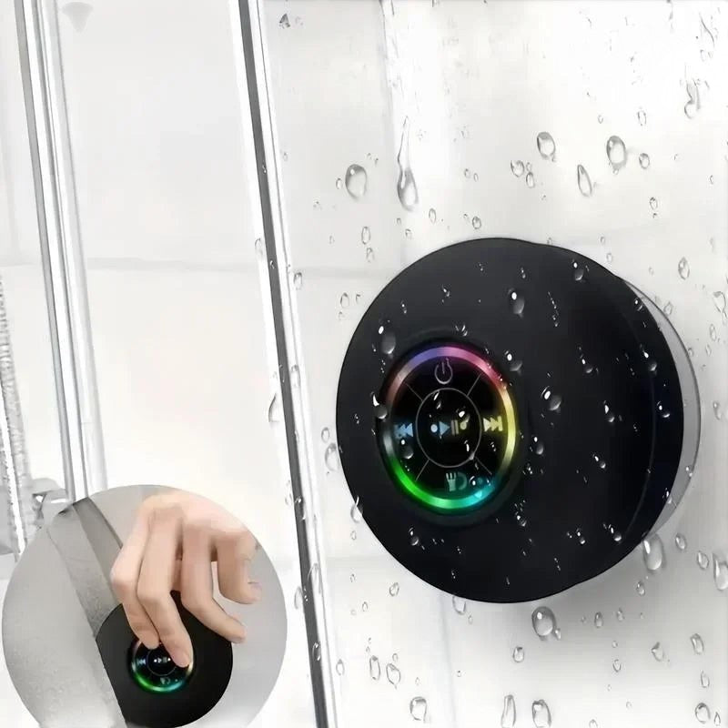 Nova Haus black waterproof Bluetooth speaker with suction cup mount and colorful LED ring, shown in a shower.