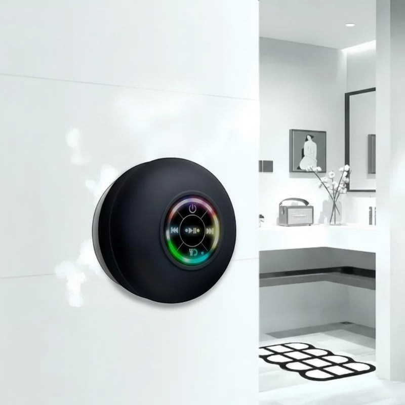 Nova Haus black waterproof Bluetooth speaker with suction cup mount and LED lighting, attached to a white tiled wall in a bathroom.