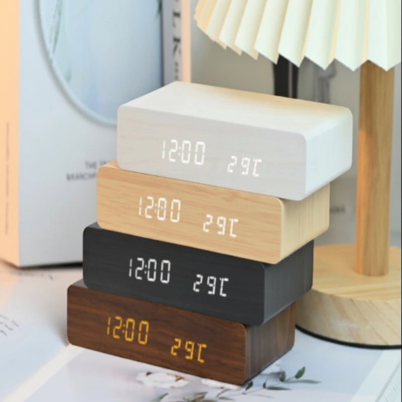 Nova Haus Rise-Charge Smart Clock in white, light wood, black, and dark wood finishes. Displays time and temperature.